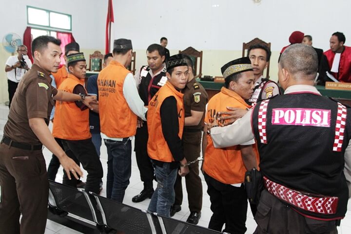 Indonesian police escort suspects including Zainal (2nd R orange jacket) charged with gang-rape and murder after their trial at a court in Curup, Bengkulu province on September 29, 2016. The leader of an Indonesian gang who murdered and gang-raped a schoolgirl was sentenced to death on September 29, in a high-profile case that led to the introduction of tougher punishments for child sex offenders. / AFP PHOTO / DIVA MARHA