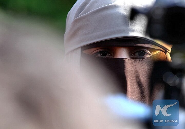 (110411) -- PARIS, April 11, 2011(Xinhua) -- Kenza Drider, a niqab veiled young woman from the southern city of Avignon, is surounded by media in front of Notre Dame Cathedral in Paris, France, April 11, 2011. France's ban on full face veils, a first in Europe, went into force today, exposing anyone who wears the Muslim niqab or burqa in public to fines of 150 euros and lessons in French citizenship.   (Xinhua/Gao Jing)