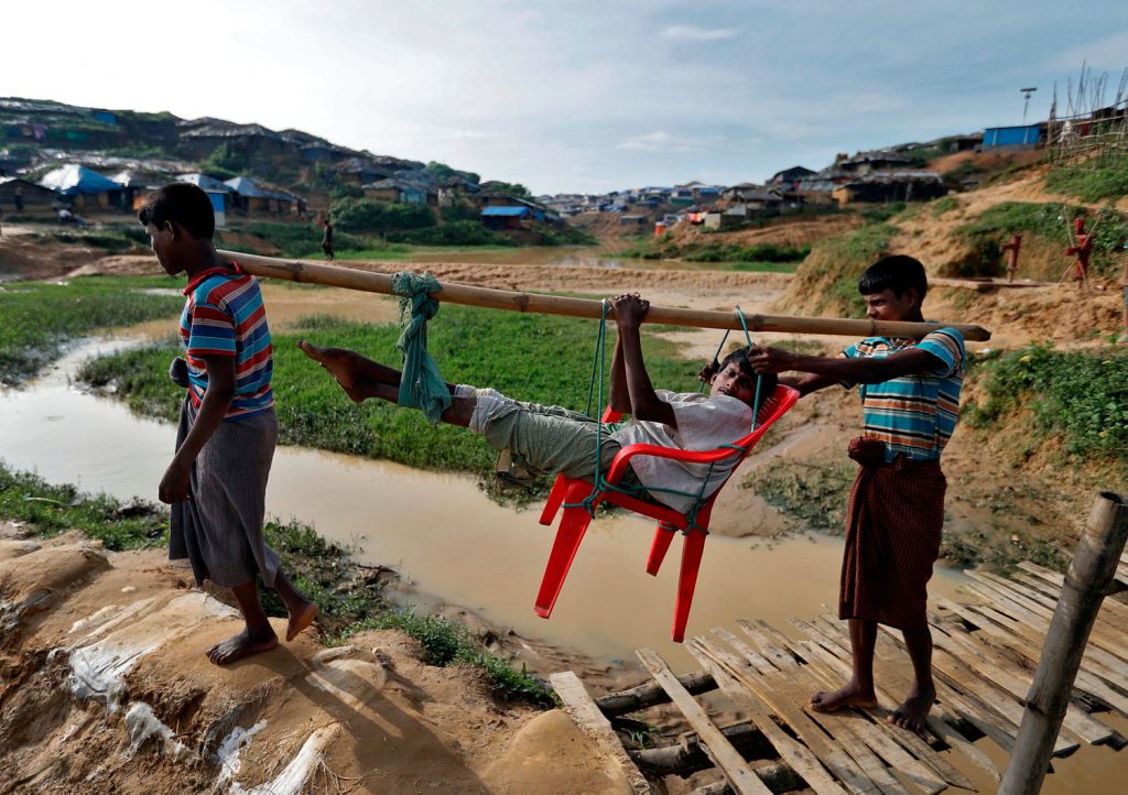 Rohingya refugees carry a man who, according to them, was beaten by the Myanmar Army before there arrival in Cox's Bazar