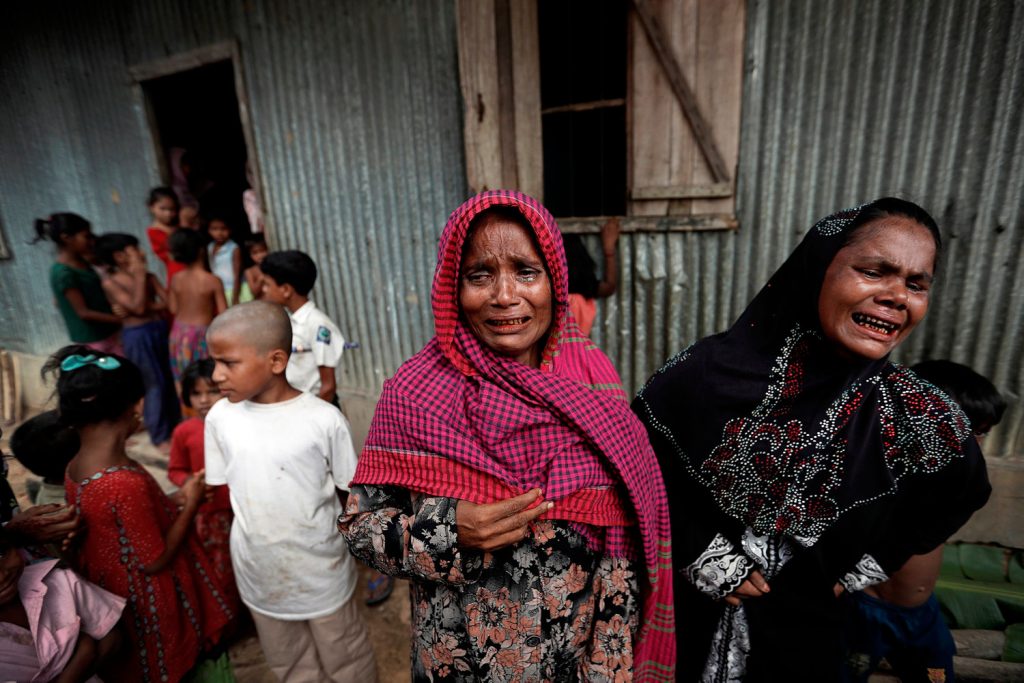 Rohingya refugees react before the funeral of a family member, whose family says he succumbed to injuries inflicted by the Myanmar Army before their arrival, in Cox's Bazar