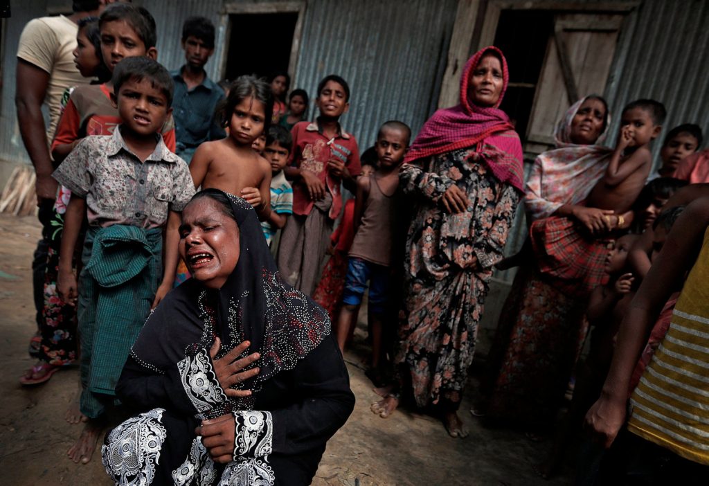 Rohingya refugees react before the funeral of a family member, whose family says he succumbed to injuries inflicted by the Myanmar Army before their arrival, in Cox's Bazar